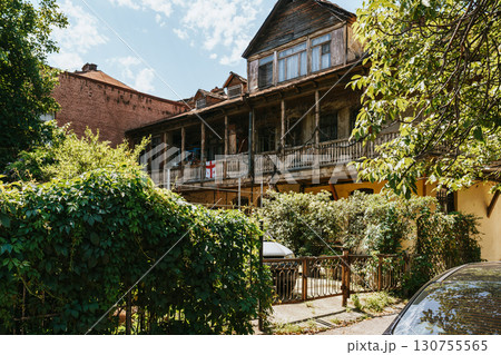 Historic wooden house in a green neighborhood on a sunny day with blue sky and lush vegetation Historic wooden house in a green neighborhood on a sunny day with blue sky and lush vegetation 130755565