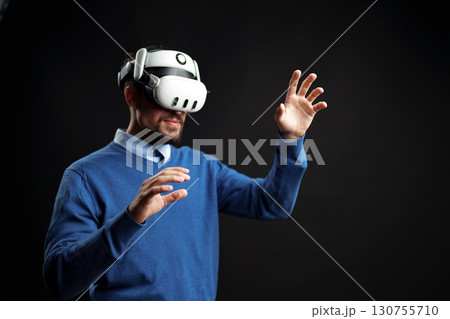 Immersive virtual reality experience with man wearing VR headset in a dark environment 130755710