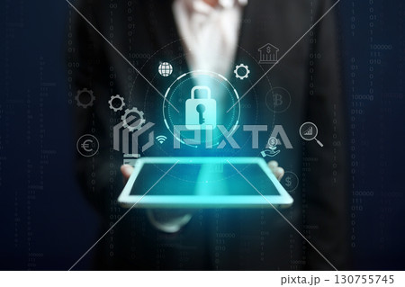 Digital security concepts displayed on a tablet held by a businessman in a suit 130755745