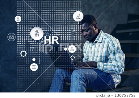 Professional engaged in human resources tasks while using a laptop in a modern office setting Professional engaged in human resources tasks while using a laptop in a modern office setting 130755758