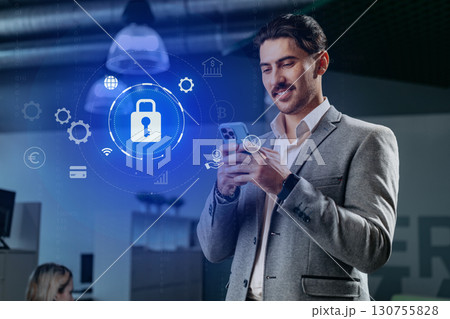 Professional man using smartphone with digital security icons in modern office environment Professional man using smartphone with digital security icons in modern office environment 130755828