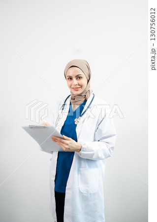 Muslim Arab person. The face of a female doctor on an isolated white background. Muslim Arab person. The face of a female doctor on an isolated white background. 130756012