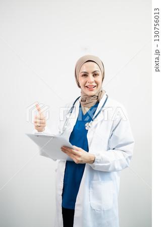 Muslim Arab person. The face of a female doctor on an isolated white background. 130756013