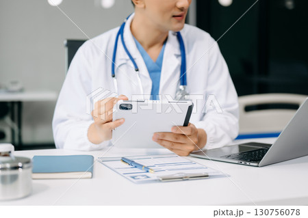 Medical technology concept. Doctor working with mobile phone and stethoscope and digital tablet laptop in modern office at hospital Medical technology concept. Doctor working with mobile phone and stethoscope and digital tablet laptop in modern office at hospital 130756078