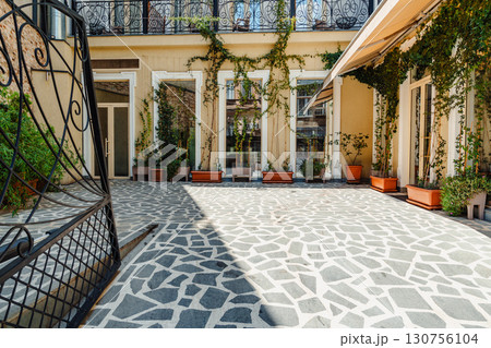 Beautiful courtyard with mosaic stone floor and potted plants in an urban setting during daytime Beautiful courtyard with mosaic stone floor and potted plants in an urban setting during daytime 130756104