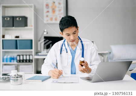 Doctor sit on table in office hospital. Attractive therapist female practitioner pharmacist smile and use tablet and laptop. after success work from treatment 130756131