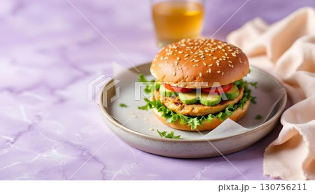 A delicious Turkey Avocado Burger with cheese, lettuce, and tomato served on a plate, perfect for summer dining 130756211