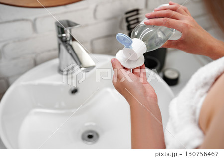 Woman preparing for her day in a modern bathroom with elegant decor and natural elements Woman preparing for her day in a modern bathroom with elegant decor and natural elements 130756467