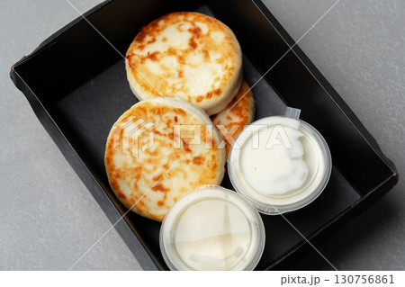 Freshly prepared biscuits paired with creamy toppings served in a black takeout container Freshly prepared biscuits paired with creamy toppings served in a black takeout container 130756861