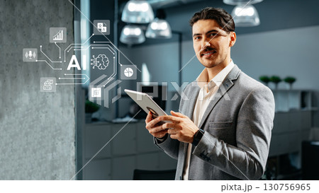 Man in business attire engages with technology, exploring artificial intelligence concepts in a modern office setting 130756965