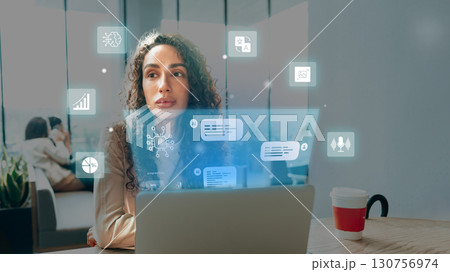 Technology and creativity blend as a woman works on a laptop in a modern workspace during the day 130756974