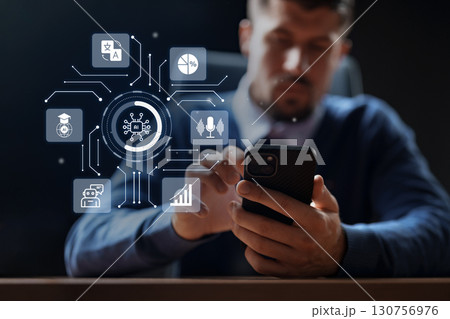 Business professional using smartphone while engaging with technology in modern office environment Business professional using smartphone while engaging with technology in modern office environment 130756976