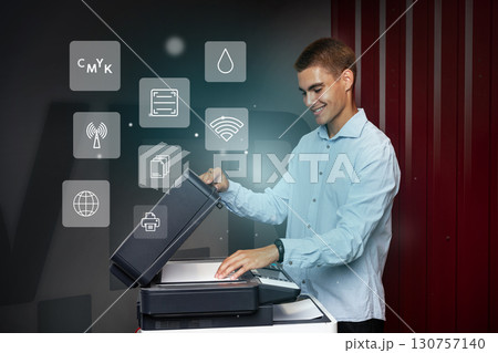 Man operates modern printer in an office setting showcasing various functions during the day Man operates modern printer in an office setting showcasing various functions during the day 130757140