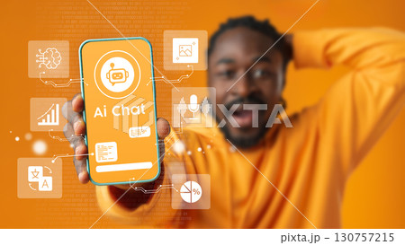 Person shows smartphone displaying AI chat application on bright orange background while expressing excitement and engagement Person shows smartphone displaying AI chat application on bright orange background while expressing excitement and engagement 130757215