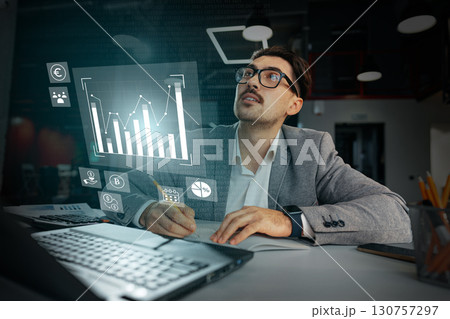 Business professional analyzing data trends in modern office space during daytime 130757297