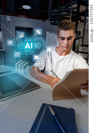 Young man applying artificial intelligence concepts while studying in a modern workspace during daylight hours Young man applying artificial intelligence concepts while studying in a modern workspace during daylight hours 130757343