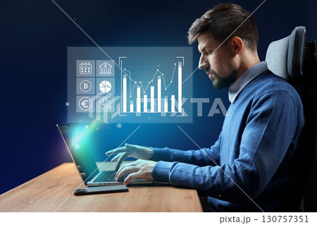 Young professional analyzes data and trends while working on a laptop in a modern office setting in the evening Young professional analyzes data and trends while working on a laptop in a modern office setting in the evening 130757351