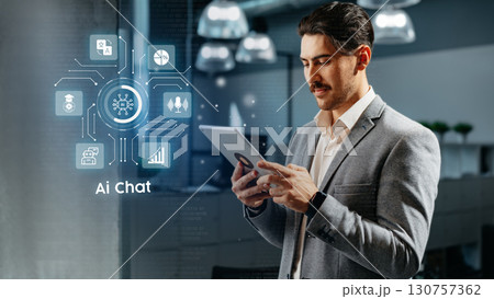 Professional man engaging with AI chat technology in an office setting during work hours 130757362