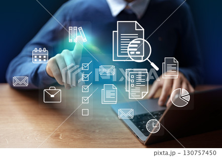 Digital workspace with a man interacting with virtual icons on a laptop during a productive session Digital workspace with a man interacting with virtual icons on a laptop during a productive session 130757450