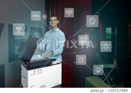Young man using a multifunction printer to scan documents while discussing digital connectivity features in a modern workspace Young man using a multifunction printer to scan documents while discussing digital connectivity features in a modern workspace 130757490