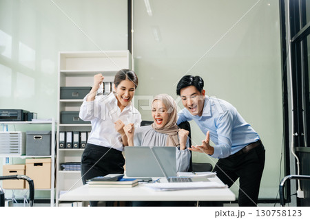 Happy businesspeople while collaborating on a new project in an office. 130758123
