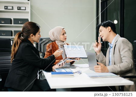 Asian businesspeople while collaborating on a new project. using a laptop and tablet Asian businesspeople while collaborating on a new project. using a laptop and tablet 130758125