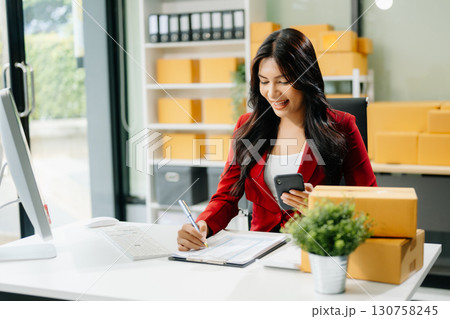 Woman Entrepreneur: SME Business mastering e-commerce with tablet, laptop, packaging, Woman Entrepreneur: SME Business mastering e-commerce with tablet, laptop, packaging, 130758245