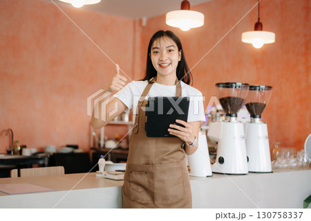 Explore professional Asian baristas brewing coffee, using notepads, digital tablets, and showcasing coffee 130758337