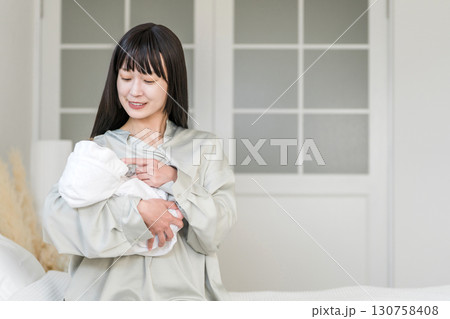 寝室,ベッドルームで赤ちゃんを抱っこする母親（あやす,寝かしつけ,育児） 130758408