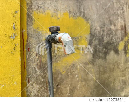 Old outdoor water tap attached to rustic concrete wall Old outdoor water tap attached to rustic concrete wall 130758644