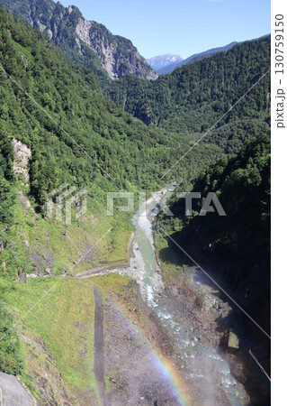 黒部ダムの堤体から見下ろす黒部川に架かる虹 130759150