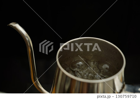 ドリップケトルの中でお湯が沸騰する様子。ペーパードリップでコーヒーを淹れる工程の連続写真。 130759710