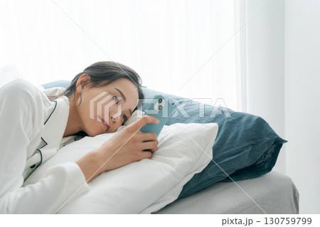 ベッドでスマホを操作する女性 ベッドでスマホを操作する女性 130759799
