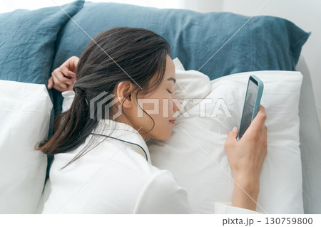 ベッドでスマホを操作する女性 ベッドでスマホを操作する女性 130759800