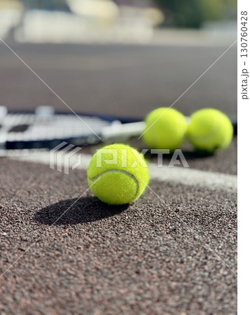 yellow tennis balls are lying on the tennis court along with a racket. High quality photo 130760428