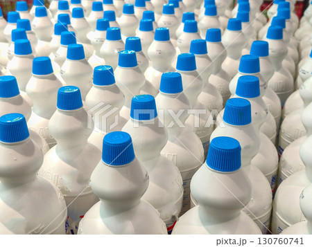 Rows of white plastic bottles with caps, perfect for concepts like cleaning products, consumer goods, and industrial supplies. 130760741