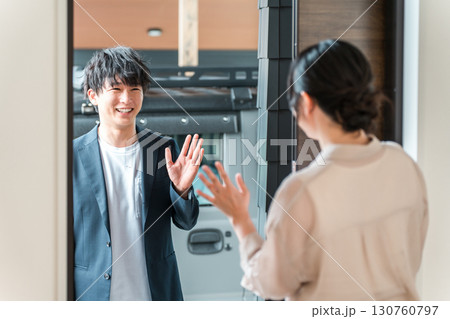 朝出勤する夫・旦那を玄関で見送りする若いアジア人女性・妻 朝出勤する夫・旦那を玄関で見送りする若いアジア人女性・妻 130760797