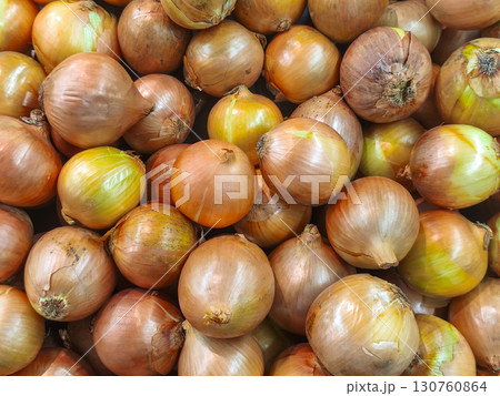 A full frame, close-up shot of a large pile of fresh yellow and brown onions. Ideal for themes of cooking ingredients, healthy vegetables, and market produce. 130760864