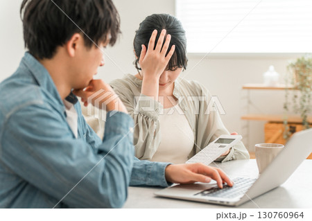 物価高騰で家計に苦しむ若いアジア人夫婦（赤字,出費,無駄遣い,ローン,返済） 130760964