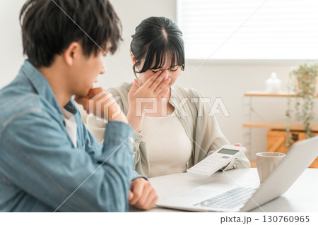 物価高騰で家計に苦しむ若いアジア人夫婦（赤字,出費,無駄遣い,ローン,返済） 130760965