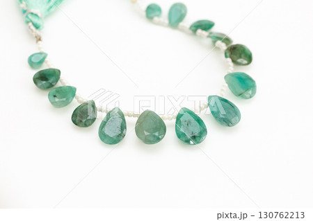 白背景に映えるエメラルドのブリオレットビーズストランドとタッセル 白背景に映えるエメラルドのブリオレットビーズストランドとタッセル 130762213
