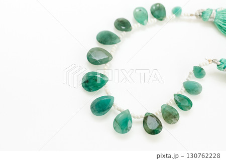 白背景に映えるエメラルドのブリオレットビーズストランドとタッセル 白背景に映えるエメラルドのブリオレットビーズストランドとタッセル 130762228