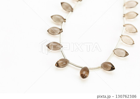 白背景に並んだスモーキークォーツのマーキスカットビーズストランド 白背景に並んだスモーキークォーツのマーキスカットビーズストランド 130762386