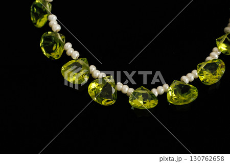 黒背景に映えるペリドットとパールのブリオレットカットルース 130762658