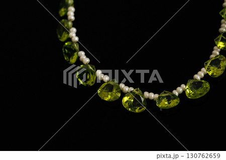 黒背景に映えるペリドットとパールのブリオレットカットルース 130762659