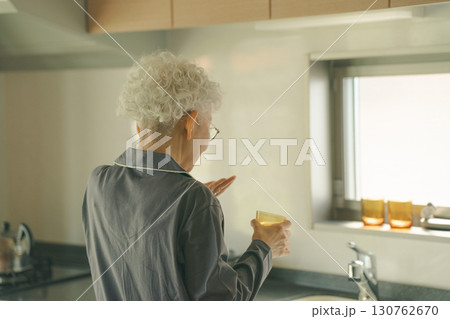 起床時に薬を飲む高齢者 130762670