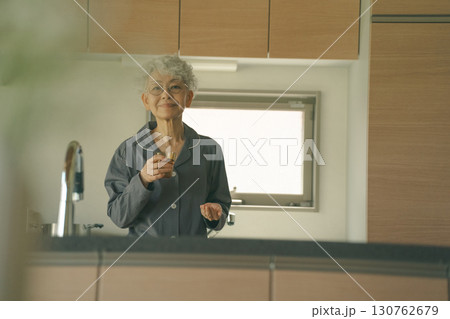 起床時に薬を飲む高齢者 130762679