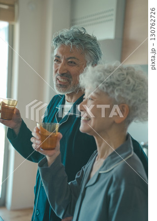 朝、水を飲む高齢夫婦 130762726