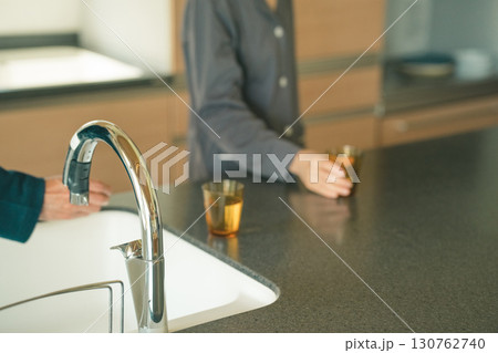 朝、水を飲む高齢夫婦 130762740