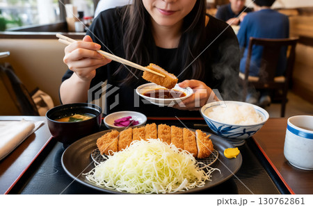 とんかつ定食を食べる女性 130762861